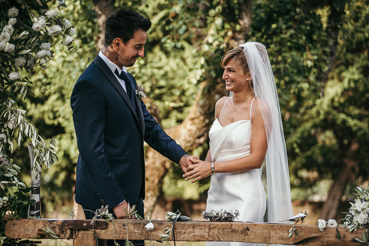 Matrimonio a Villa Delfini di Morsasco (AL) nel Monferrato. Cerimonia. sposa prende la mano dello sposo.