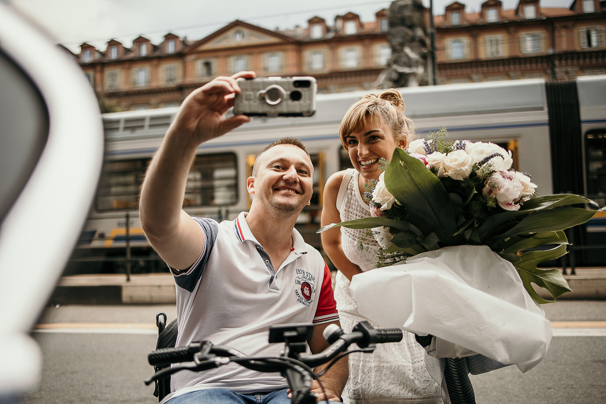 Matrimonio a Torino in un palazzo storico di Piazza Statuto. Preparazione della sposa. Passante disabile chiede un selfie alla sposa.