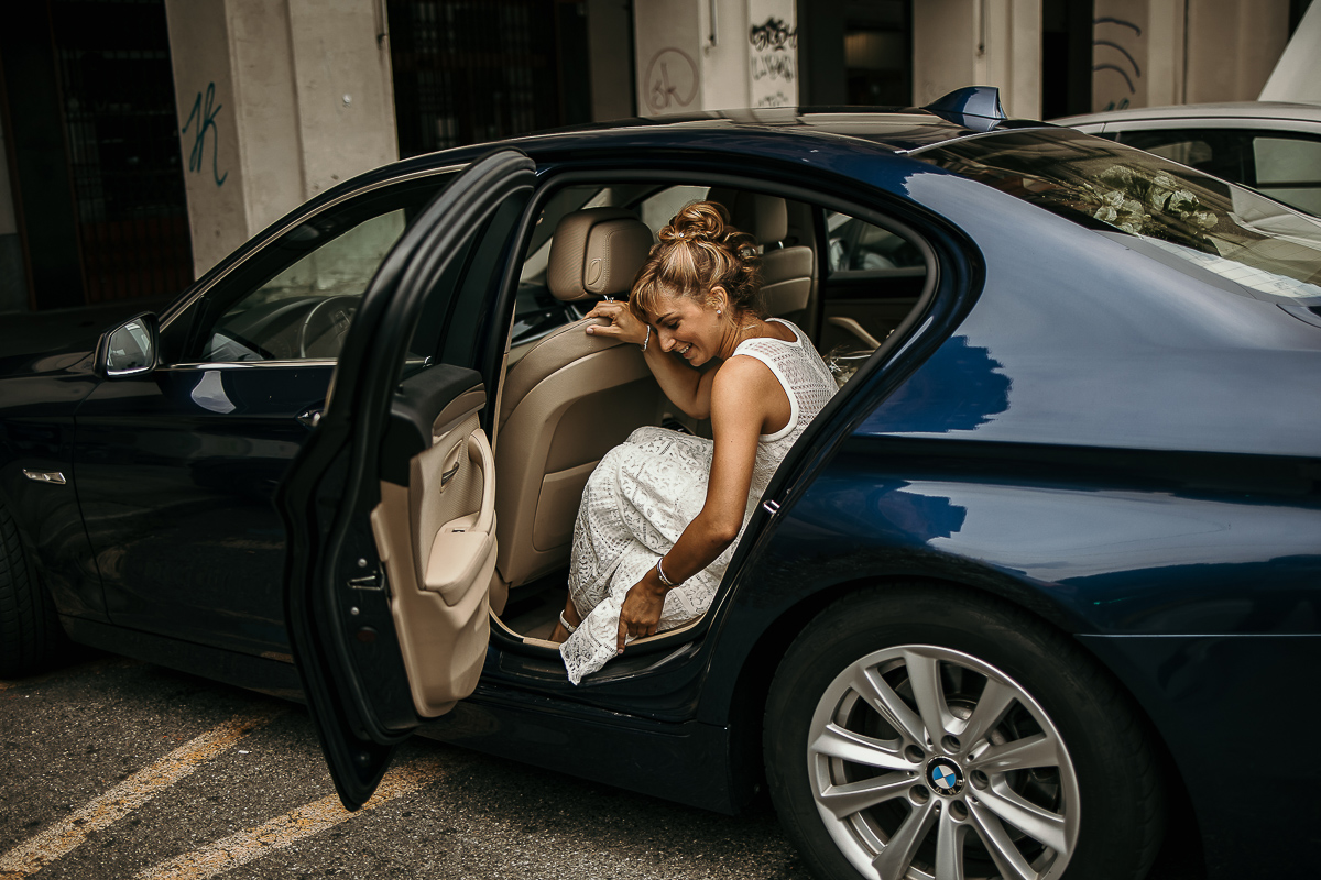 Matrimonio a Torino in un palazzo storico di Piazza Statuto. Preparazione della sposa. Sposa entra in auto.