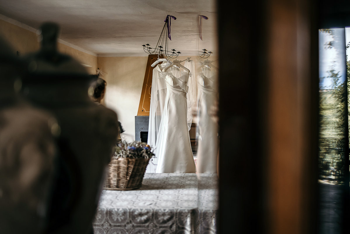 Matrimonio a Villa Delfini di Morsasco (AL) nel Monferrato. Preparazione dell a sposa. Abito appeso ad un lampadario.