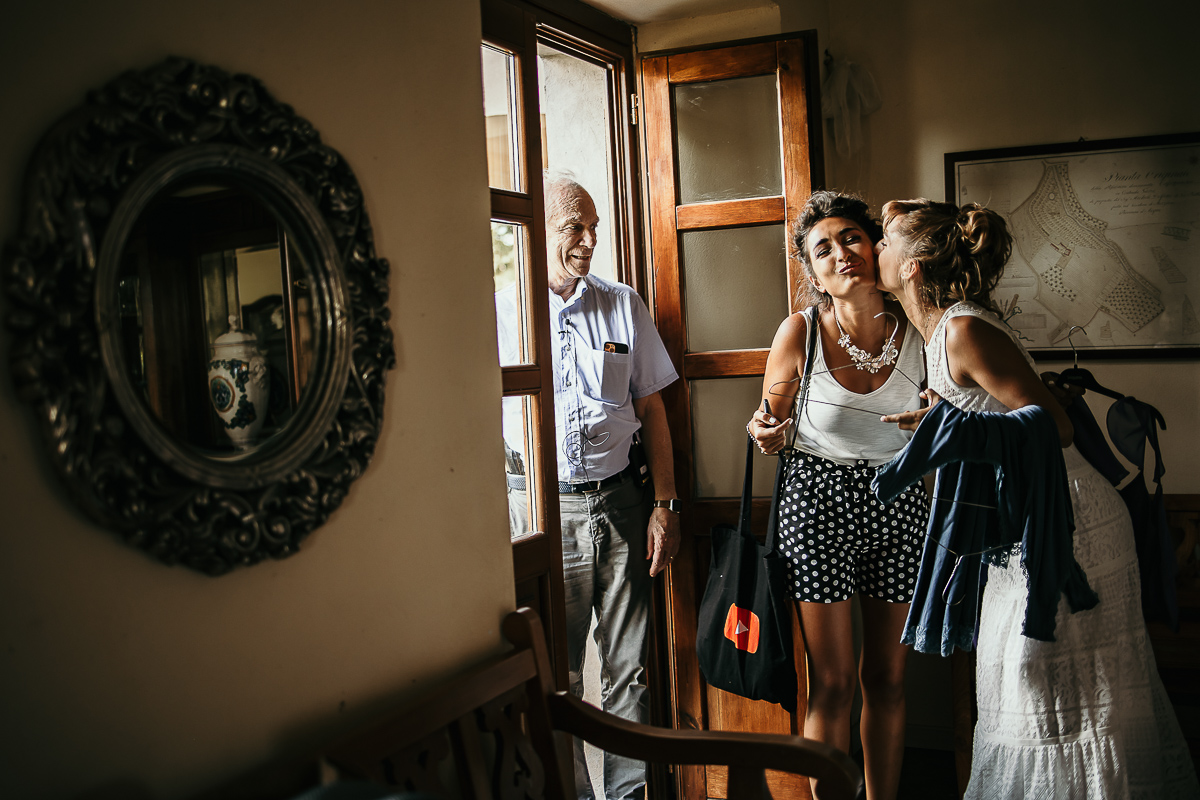 Matrimonio a Villa Delfini di Morsasco (AL) nel Monferrato. Preparazione dell a sposa. Sposa bacia la damigella d'onore.