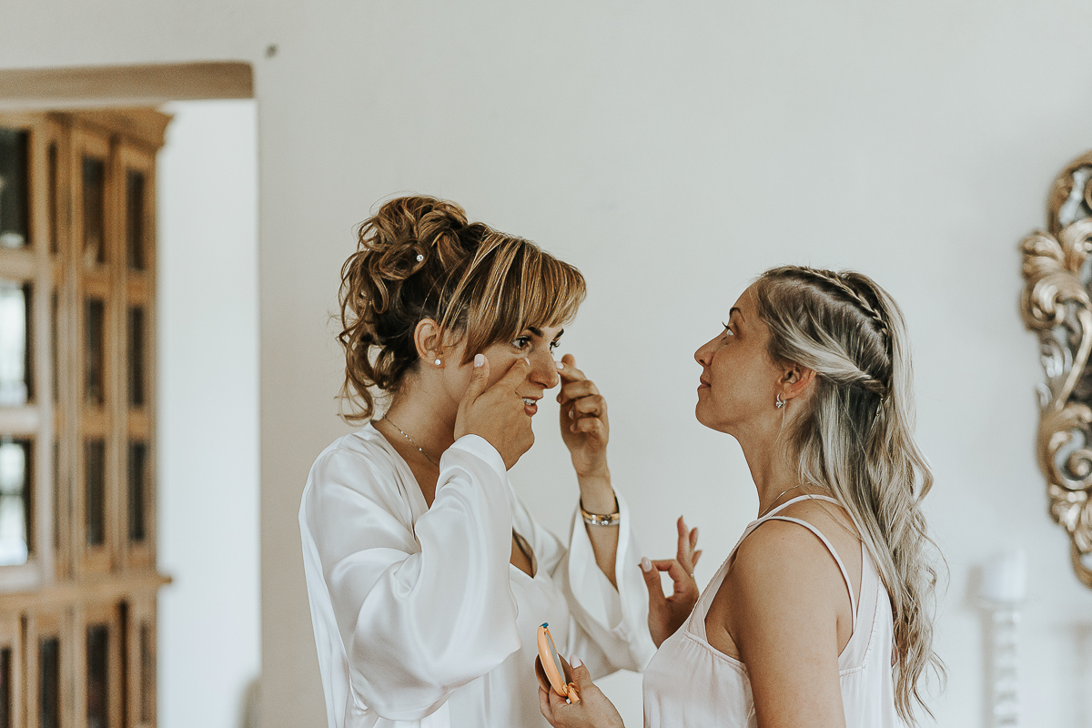 Matrimonio a Villa Delfini di Morsasco (AL) nel Monferrato. Preparazione dell a sposa. Damigella ritocca il trucco della sposa.