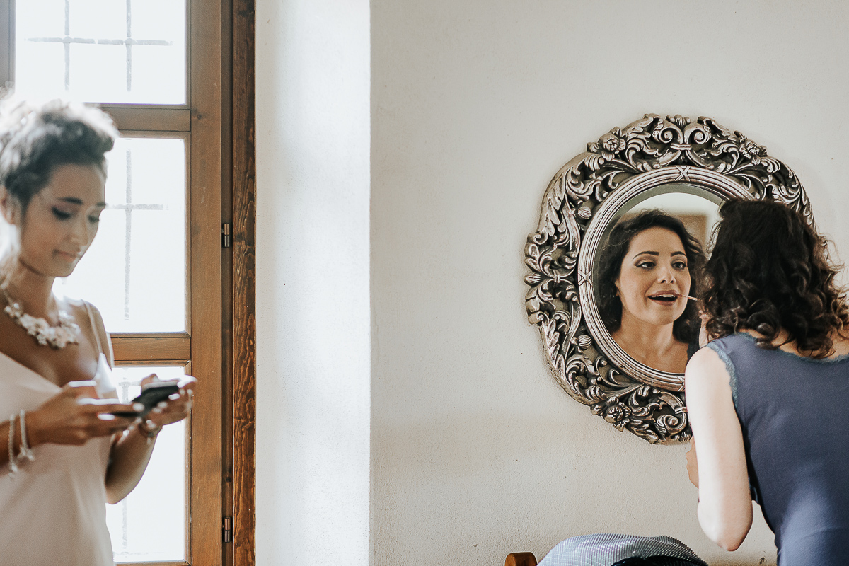 Matrimonio a Villa Delfini di Morsasco (AL) nel Monferrato. Preparazione dell a sposa. Damigella si mtte il rossetto.