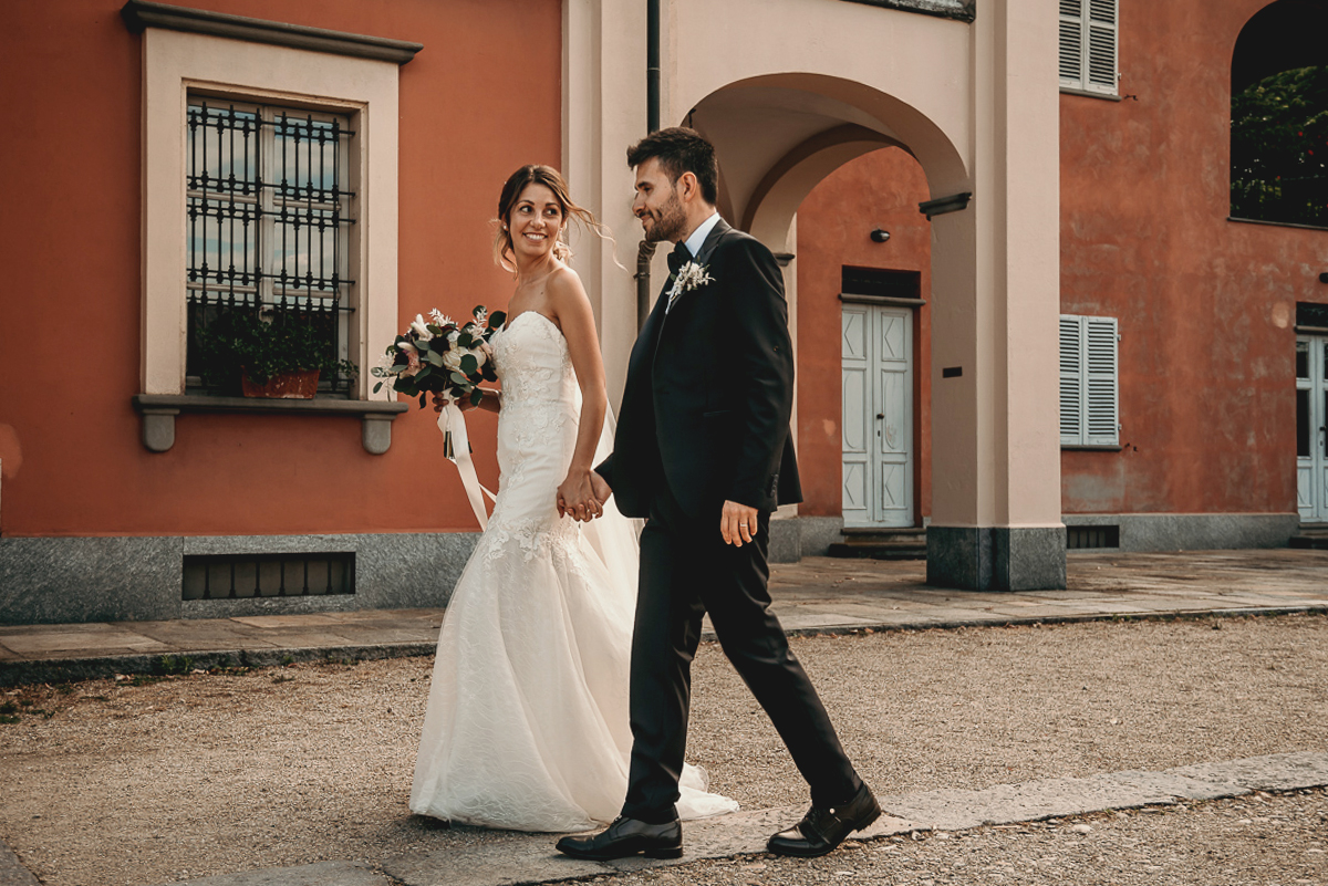 Matrimonio a Villa Fiorita ad Asti. Servizio di coppia.Sposi che vanno verso la zona aperitivo
