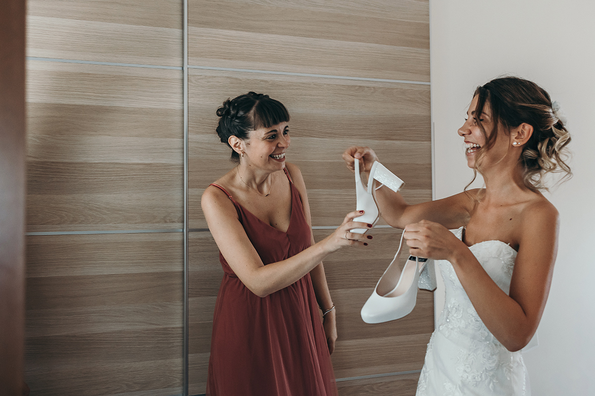 Matrimonio a Villa Fiorita ad Asti. Preparazione della sposa.Sposa che mostra le scarpe alla sorella