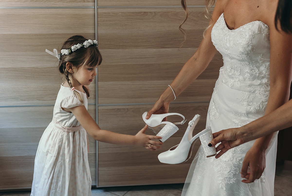 Matrimonio a Villa Fiorita ad Asti. Preparazione della sposa.Sposa con la nipotina e le scarpe