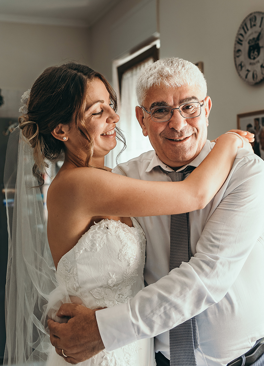 Matrimonio a Villa Fiorita ad Asti. Preparazione della sposa.Papà che abbraccia la sposa.