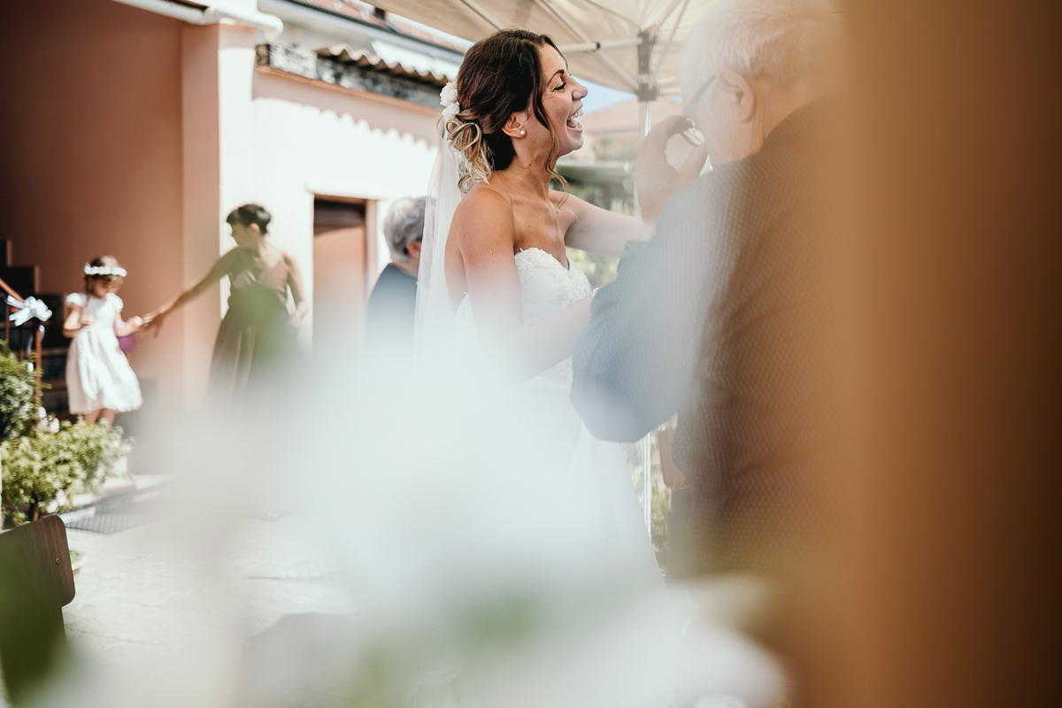 Matrimonio a Villa Fiorita ad Asti. Preparazione della sposa.Sposa nel cortile di casa al rinfresco con alcuni invitati