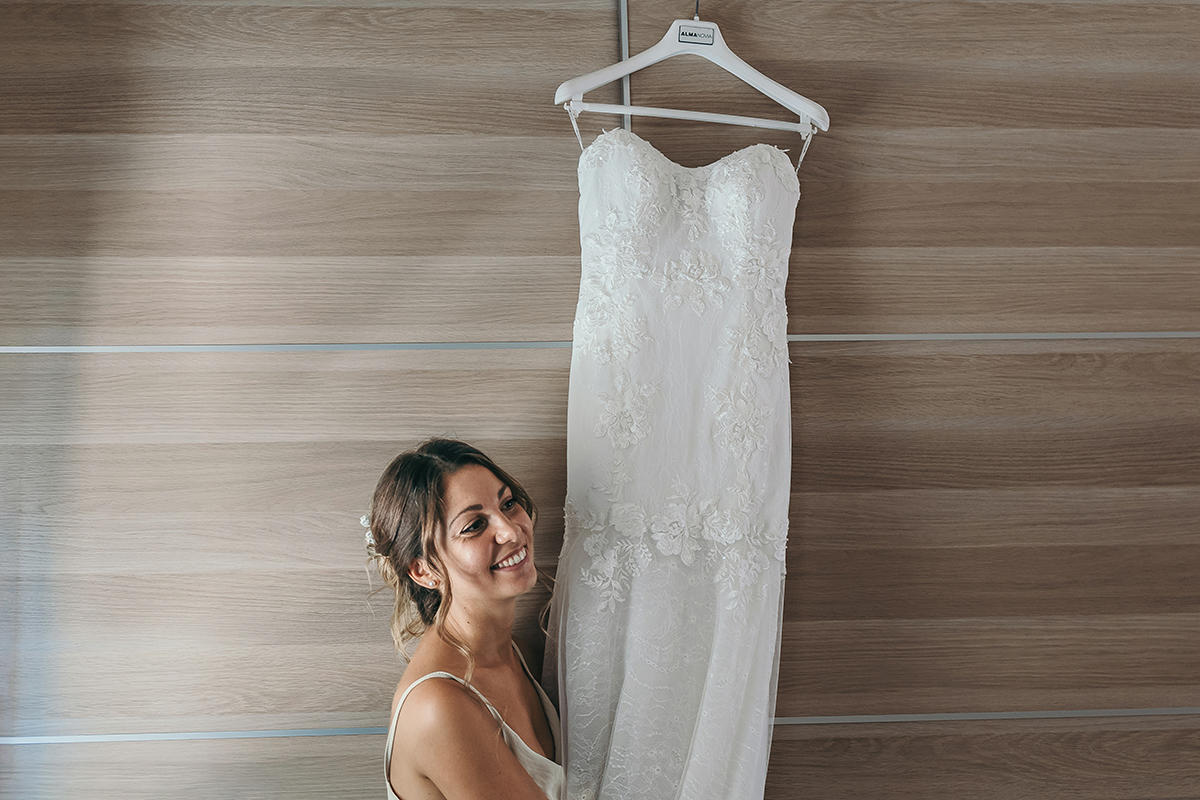 Matrimonio a Villa Fiorita ad Asti. Preparazione della sposa.Sposa che accarezza il suo abito