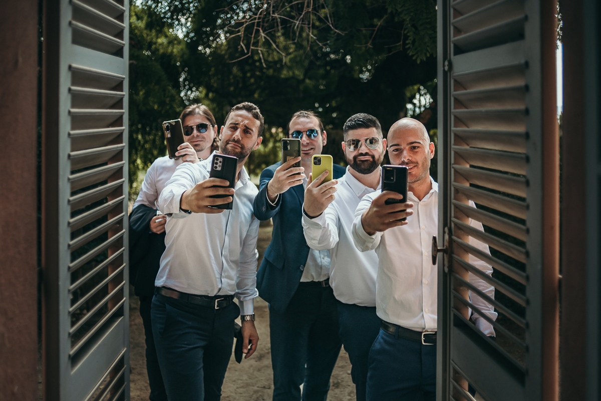 Matrimonio a Villa Fiorita ad Asti. Preparazione dello sposo.Amici dello sposo che scattano delle fotografie con il cellulare.