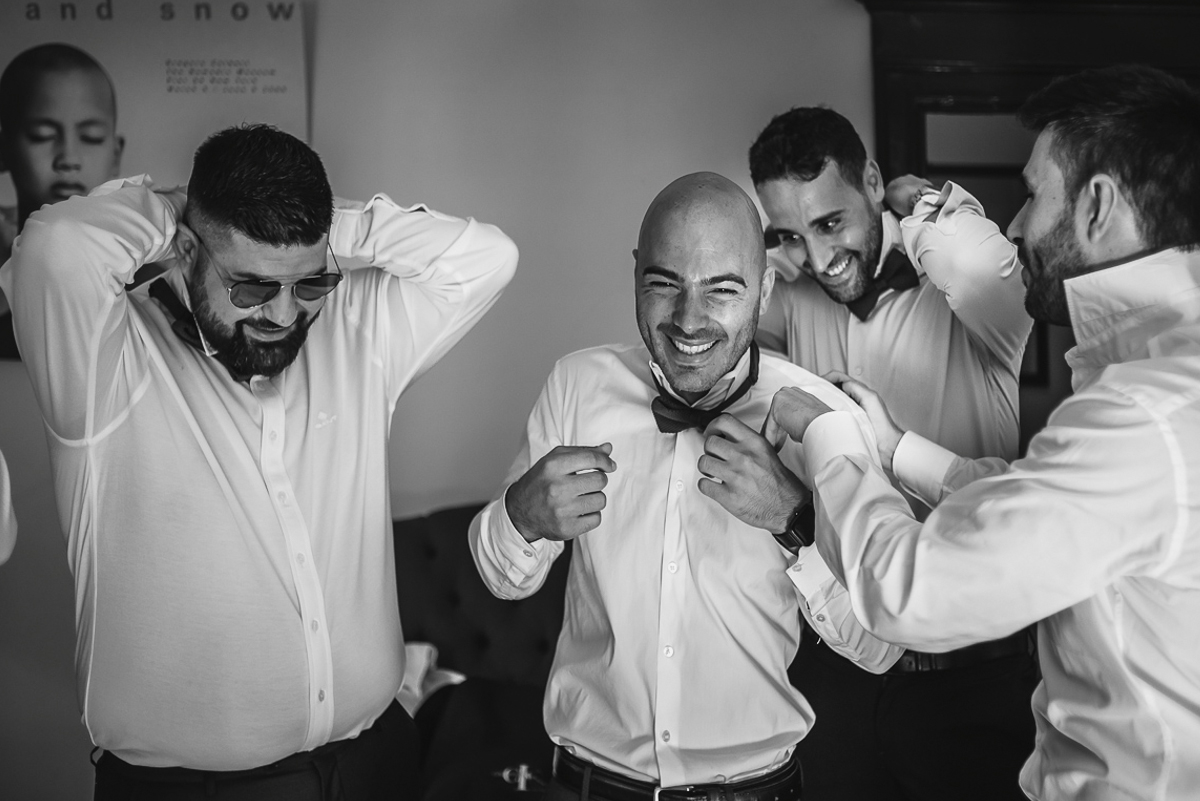 Matrimonio a Villa Fiorita ad Asti. Preparazione dello sposo.Testimoni e amici dello sposo che si sitemano i papillons