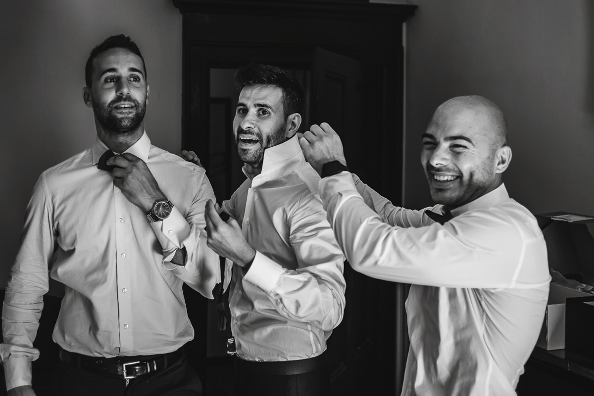 Matrimonio a Villa Fiorita ad Asti. Preparazione dello sposo.Amici che aiutano lo sposo nella vestizione
