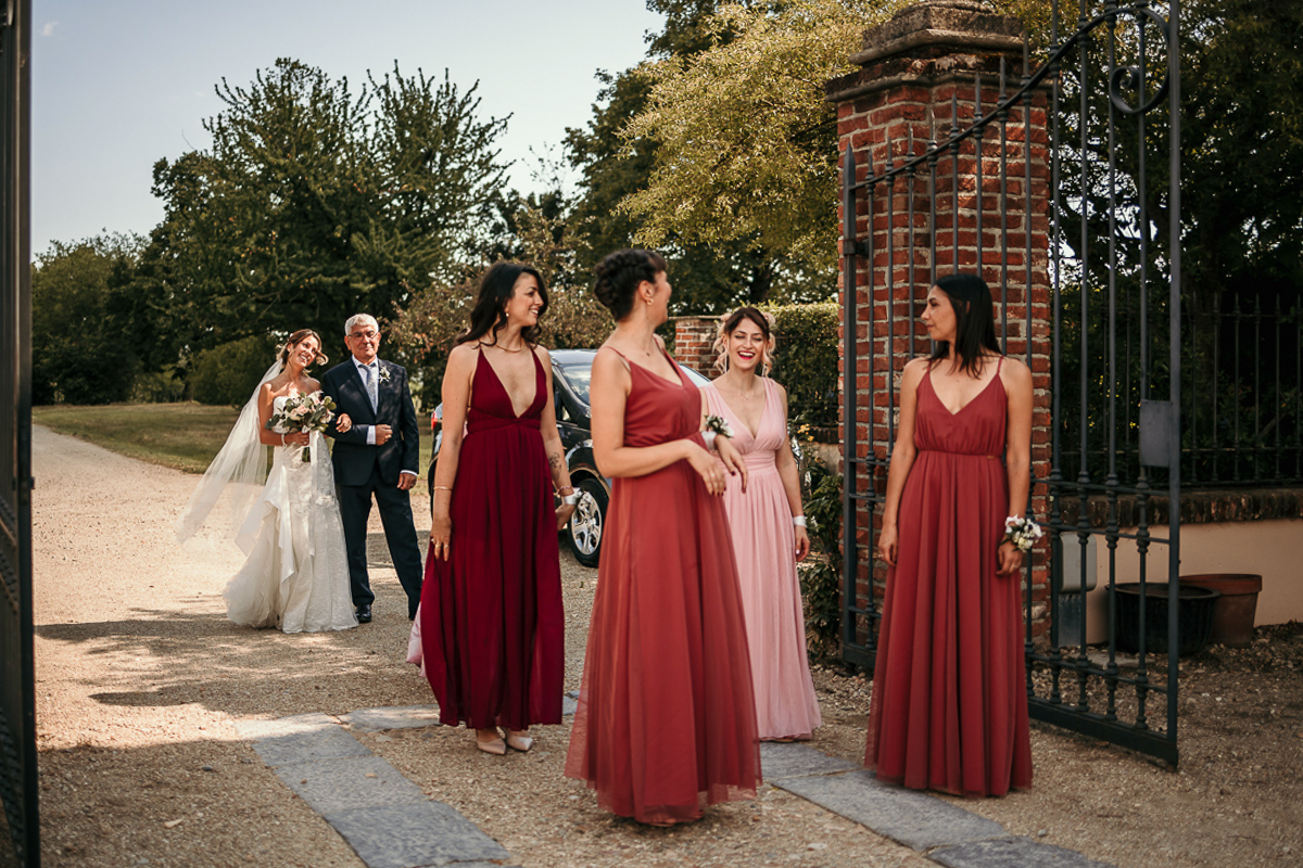 Matrimonio a Villa Fiorita ad Asti. Cerimonia.Corteso. Damigelle e dietro la sposa con il padre.