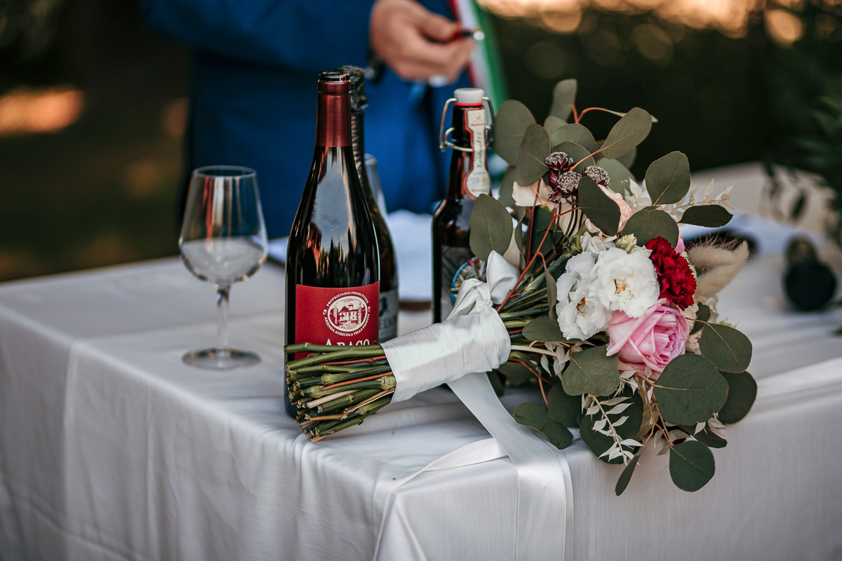 Matrimonio a Villa Fiorita ad Asti. Cerimonia.Bouquet e bottiglie di vino.