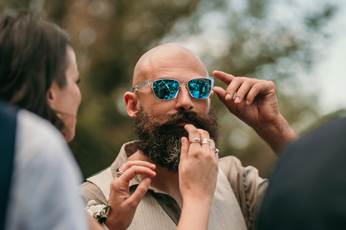 Matrimonio a Villa Fiorita ad Asti. Cerimonia.Invitato con occhiali a specchio nei quali si riflette la sposa
