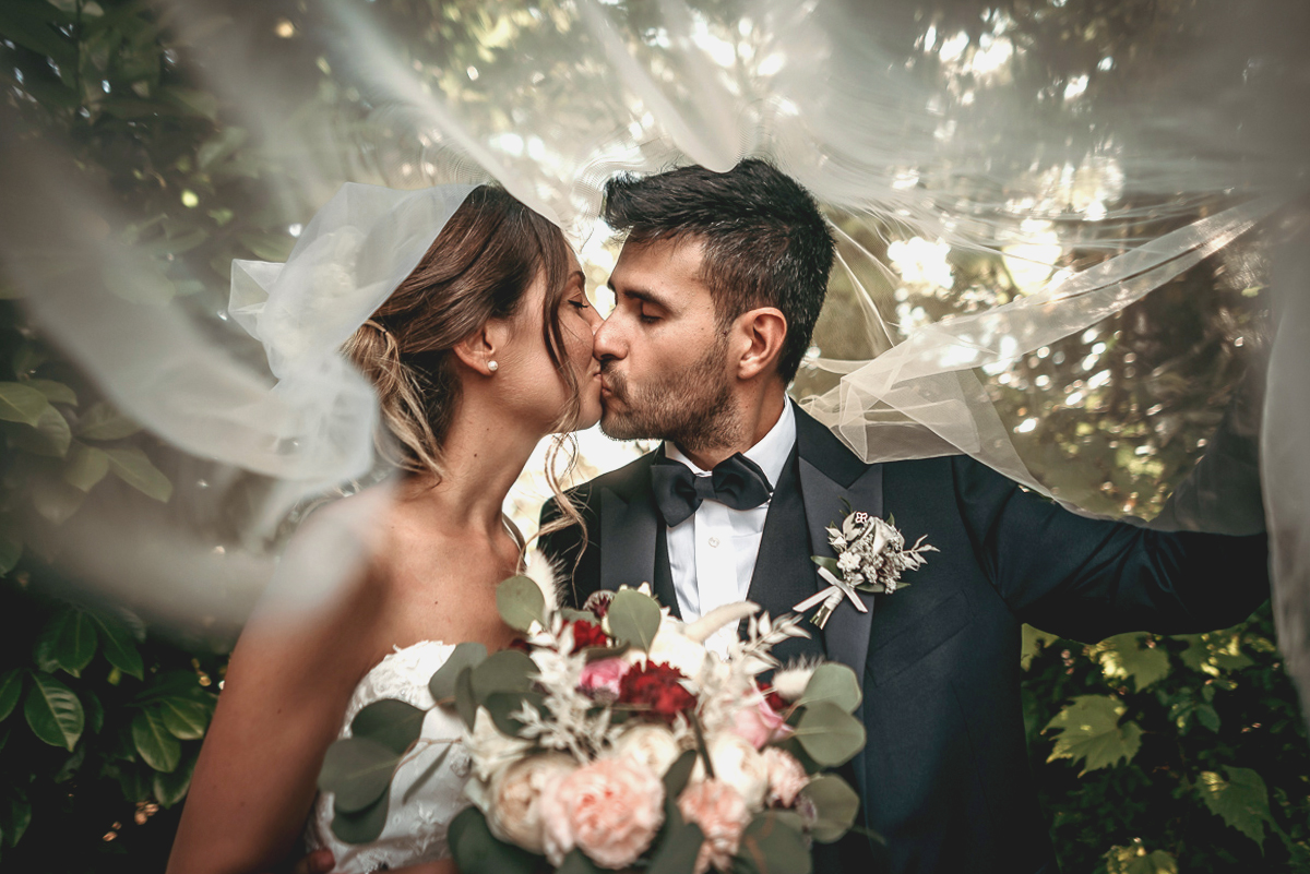 Matrimonio a Villa Fiorita ad Asti. Servizio di coppia. sposi che si baciano sotto il velo