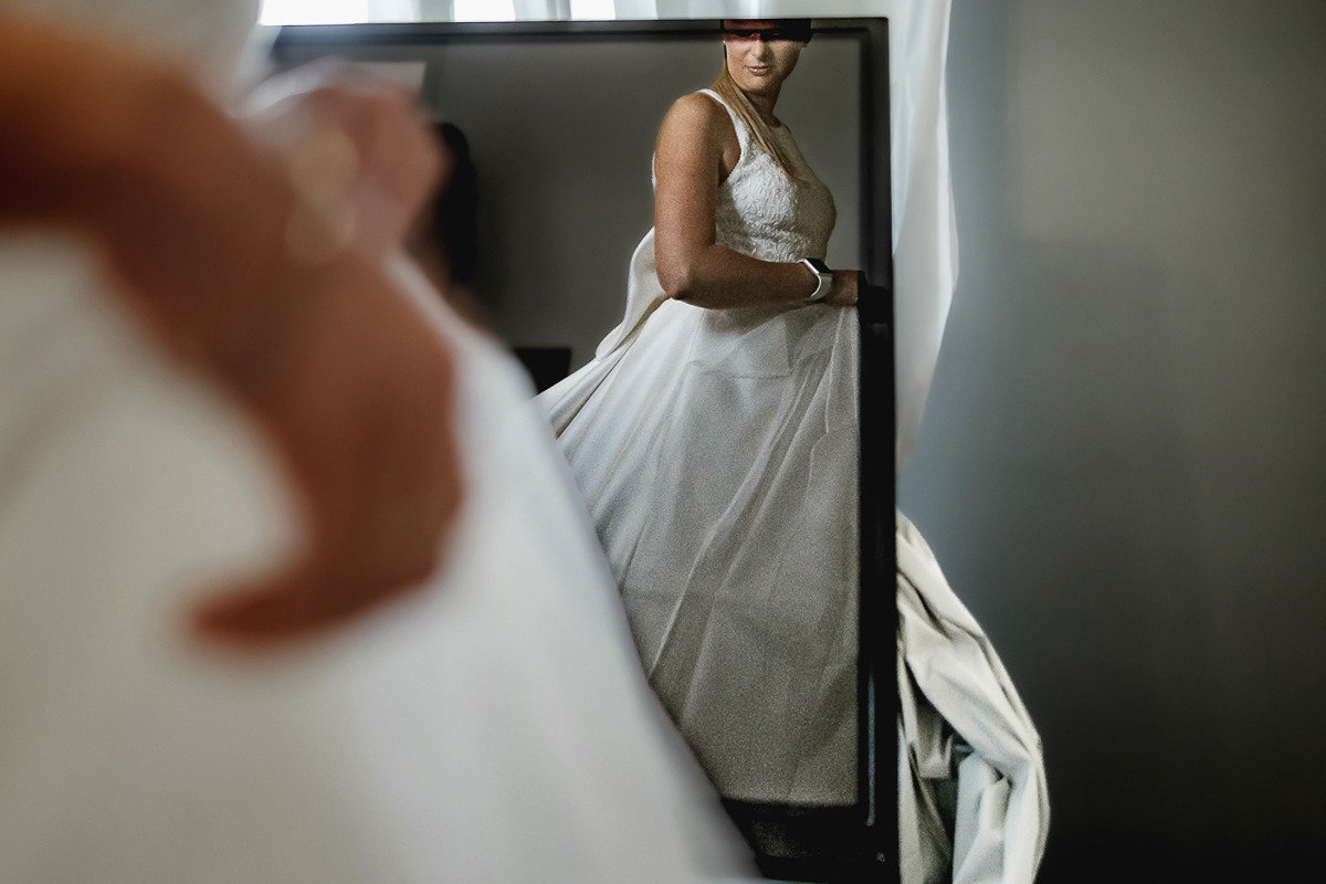 Matrimonio a Villa Sassi. Preparazione della sposa a Chieri. Sposa riflessa nel televisore.