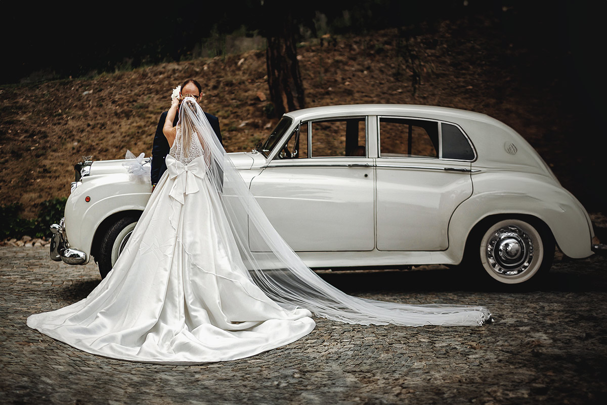 Villa Sassi matrimonio di Giulia e Nicolò. Ritratto degli sposi davanti all'auto d'epoca bianca.