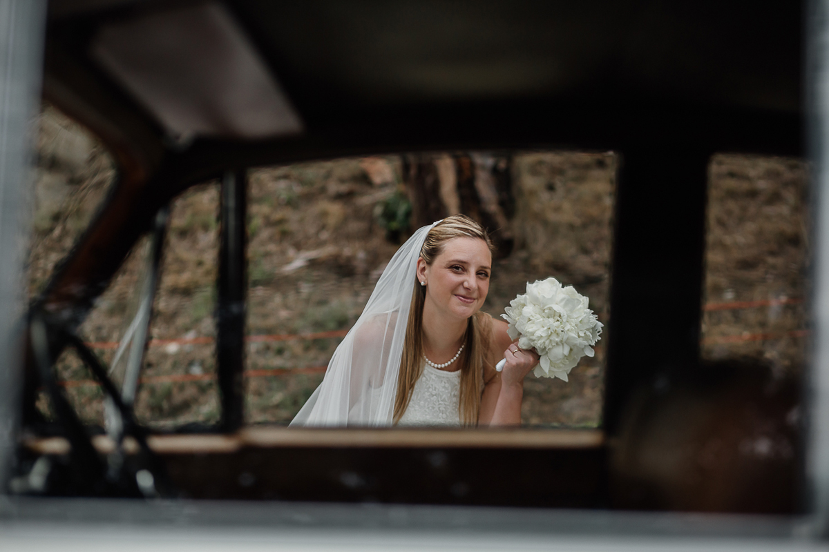 Villa Sassi matrimonio di Giulia e Nicolò. Ritratto degli sposi. Sposa attraverso il finestrino dell'auto.
