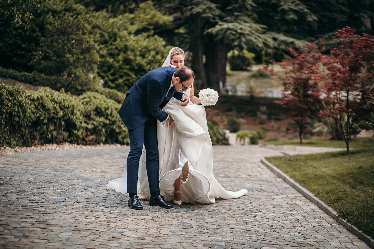 Villa Sassi matrimonio di Giulia e Nicolò. Ritratto degli sposi. Sposo sistema l'abito alla sposa.