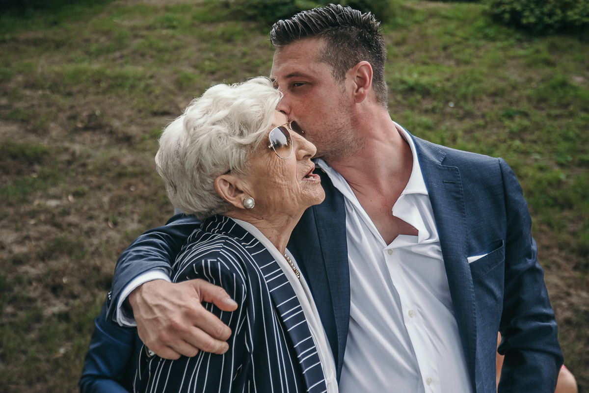Villa Sassi matrimonio di Giulia e Nicolò. Aperitivo. fratello della sposa bacia la nonna.