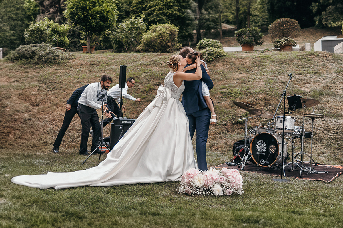 Villa Sassi matrimonio di Giulia e Nicolò. Aperitivo. Sposi abbracciano la loro bambina.