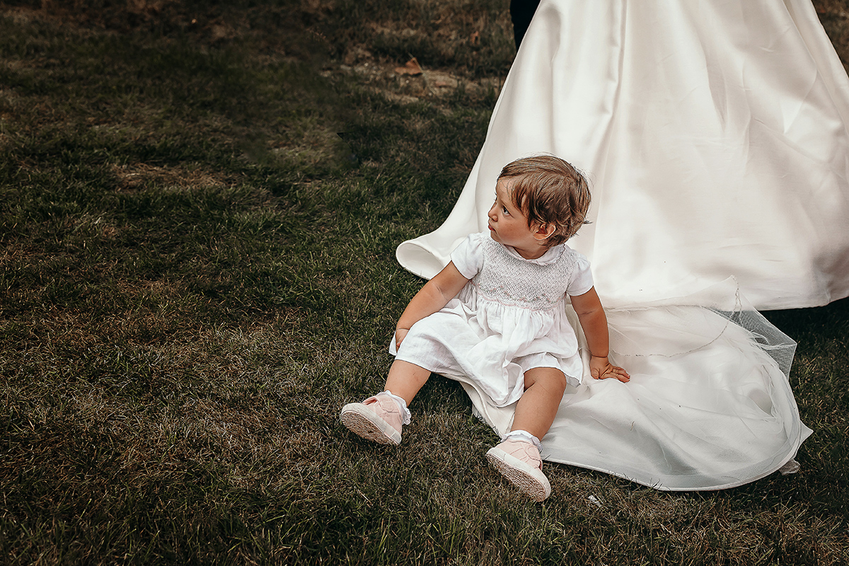 Villa Sassi matrimonio di Giulia e Nicolò. Aperitivo.Bambina seduta sull'abito della sposa.