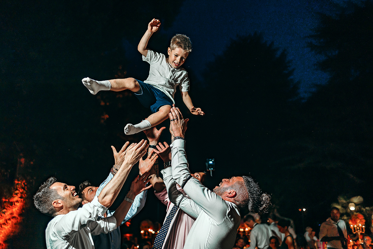 Villa Sassi matrimonio di Giulia e Nicolò.Festa.Invitati fanno volare un bambino.