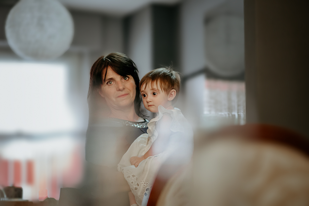 Matrimonio a Villa Sassi. Preparazione della sposa a Chieri. Figlia più piccola degli sposi in braccio alla baby sitter.
