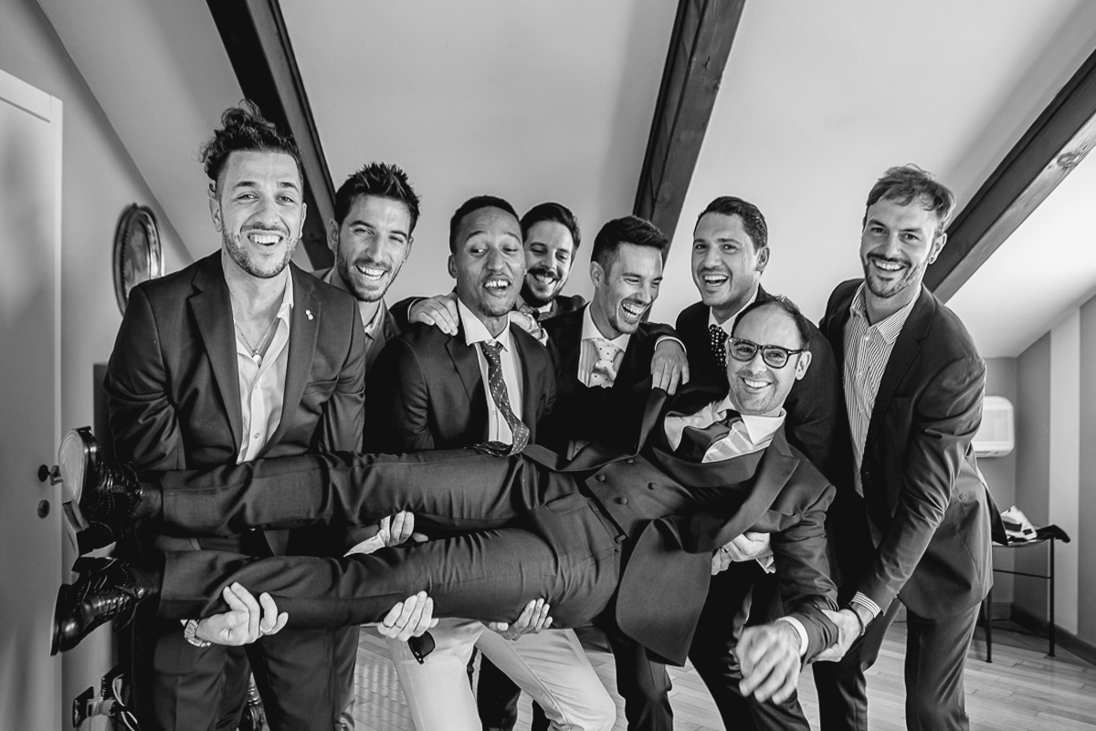 Matrimonio a Villa Sassi. Preparazione dello sposo a Baldissero Torinese. Amici sollevano lo sposo.