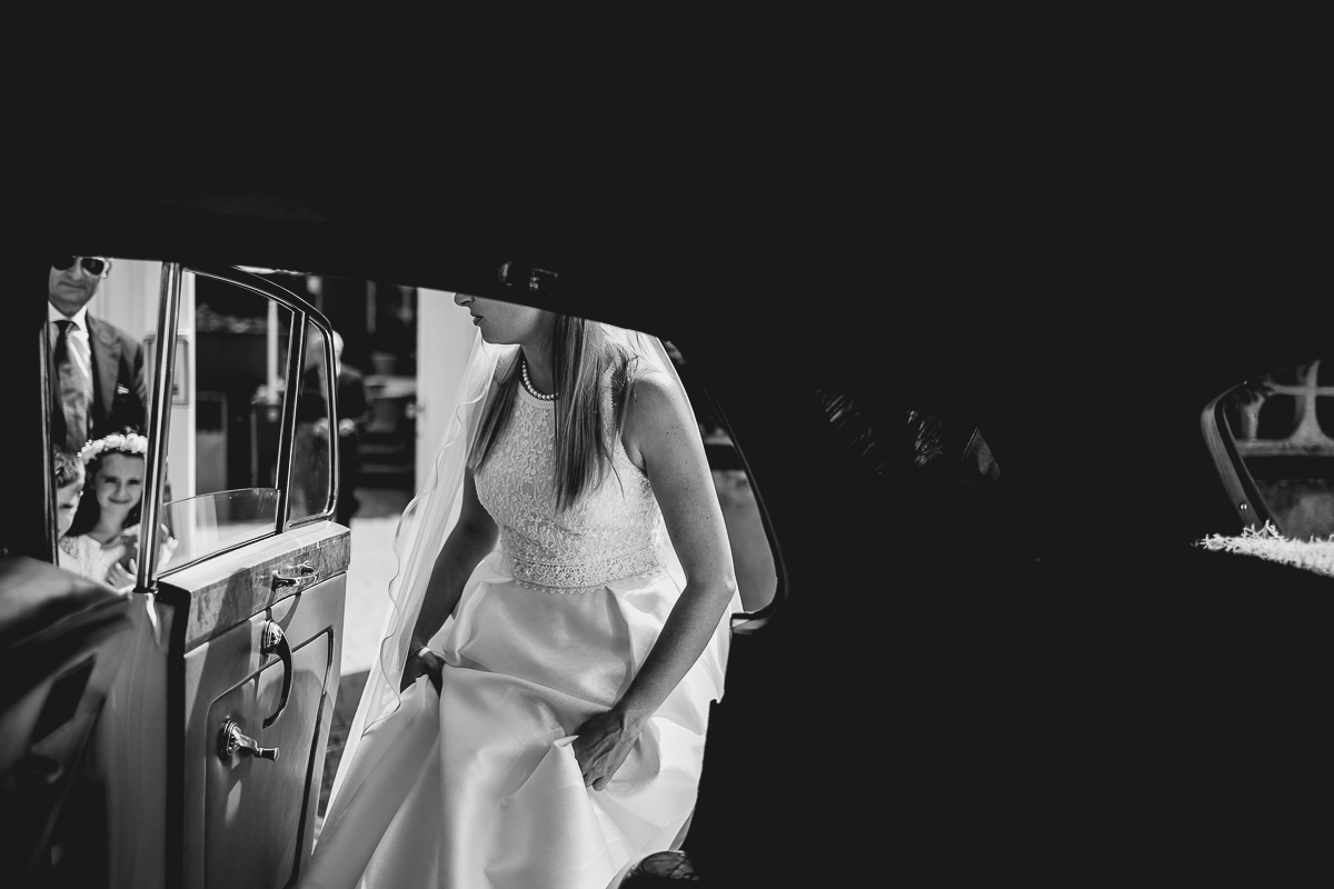 Matrimonio a Villa Sassi. Preparazione della sposa a Chieri. Auto d'epoca bianca. Sposa entra in auto. Bianco e nero.