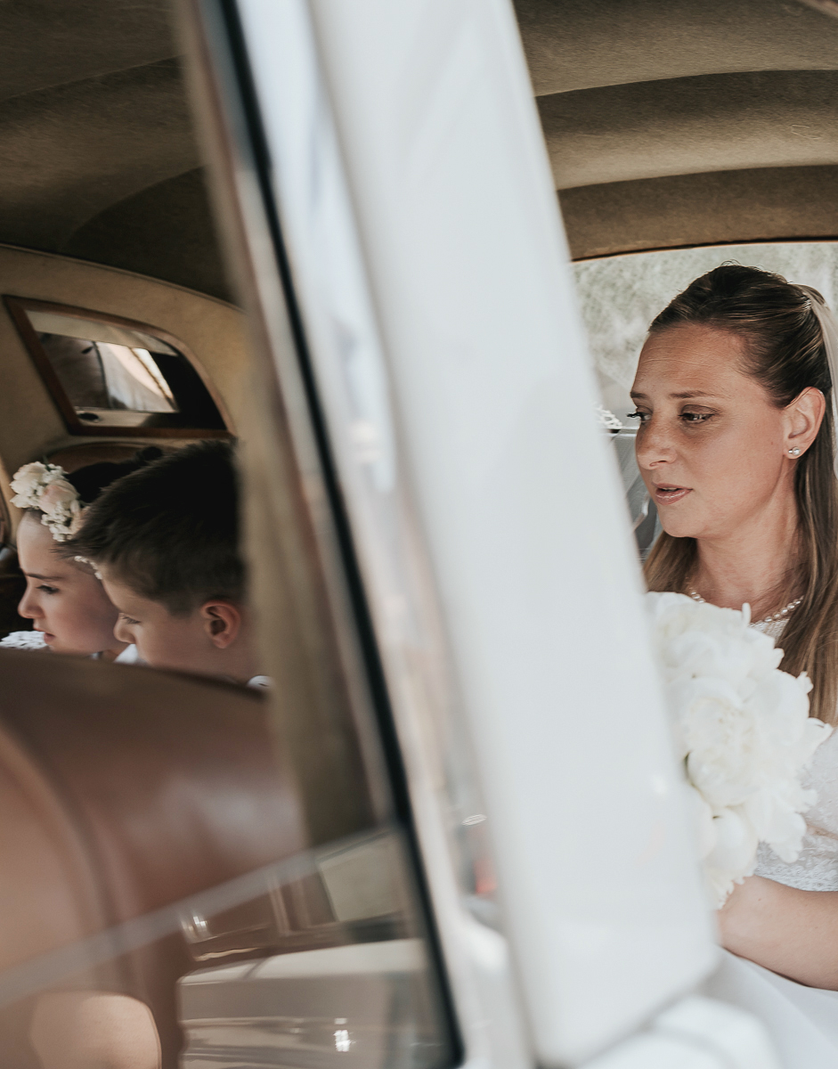 Matrimonio a Villa Sassi. Preparazione della sposa a Chieri. Auto d'epoca bianca. Sposa entra in auto.