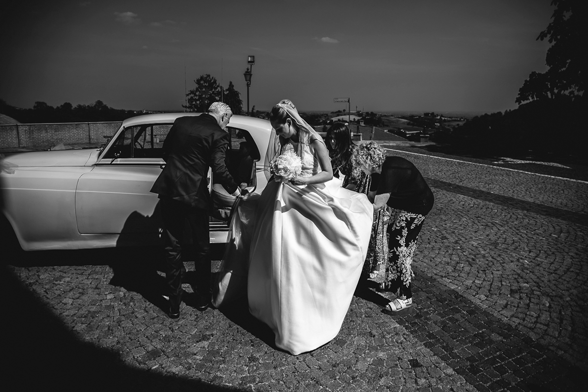 Villa Sassi matrimonio di Giulia e Nicolò. Cerimonia nella chiesa di santa Maria della Spina a Baldissero Torinese. Sposa esce dall'auto d'epoca bianca.