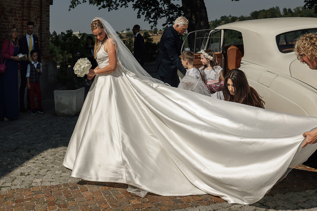 Villa Sassi matrimonio di Giulia e Nicolò. Cerimonia nella chiesa di santa Maria della Spina a Baldissero Torinese. Sposa esce dall'auto d'epoca bianca.