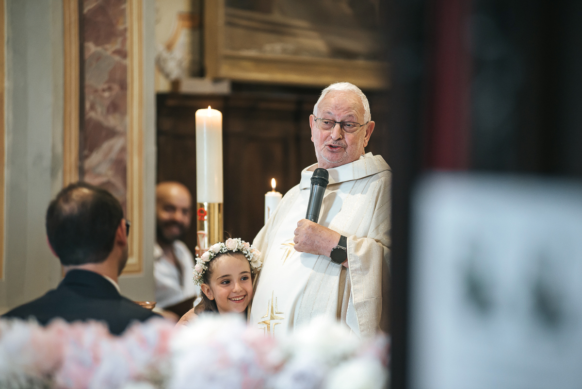 Villa Sassi matrimonio di Giulia e Nicolò. Cerimonia nella chiesa di santa Maria della Spina a Baldissero Torinese. predica del sacerdote che abbraccia la figlia degli sposi.