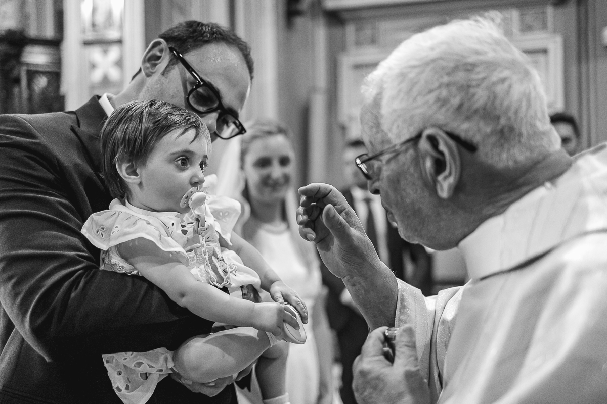 Villa Sassi matrimonio di Giulia e Nicolò. Cerimonia nella chiesa di santa Maria della Spina a Baldissero Torinese, rito del Battesimo.. Bambina in braccio al padre.