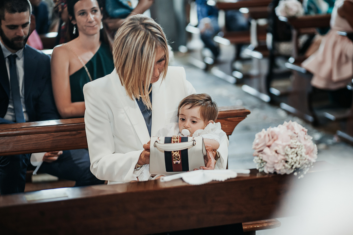 Villa Sassi matrimonio di Giulia e Nicolò. Cerimonia nella chiesa di santa Maria della Spina a Baldissero Torinese. Bambina in braccio alla nonna, madre dello sposo.