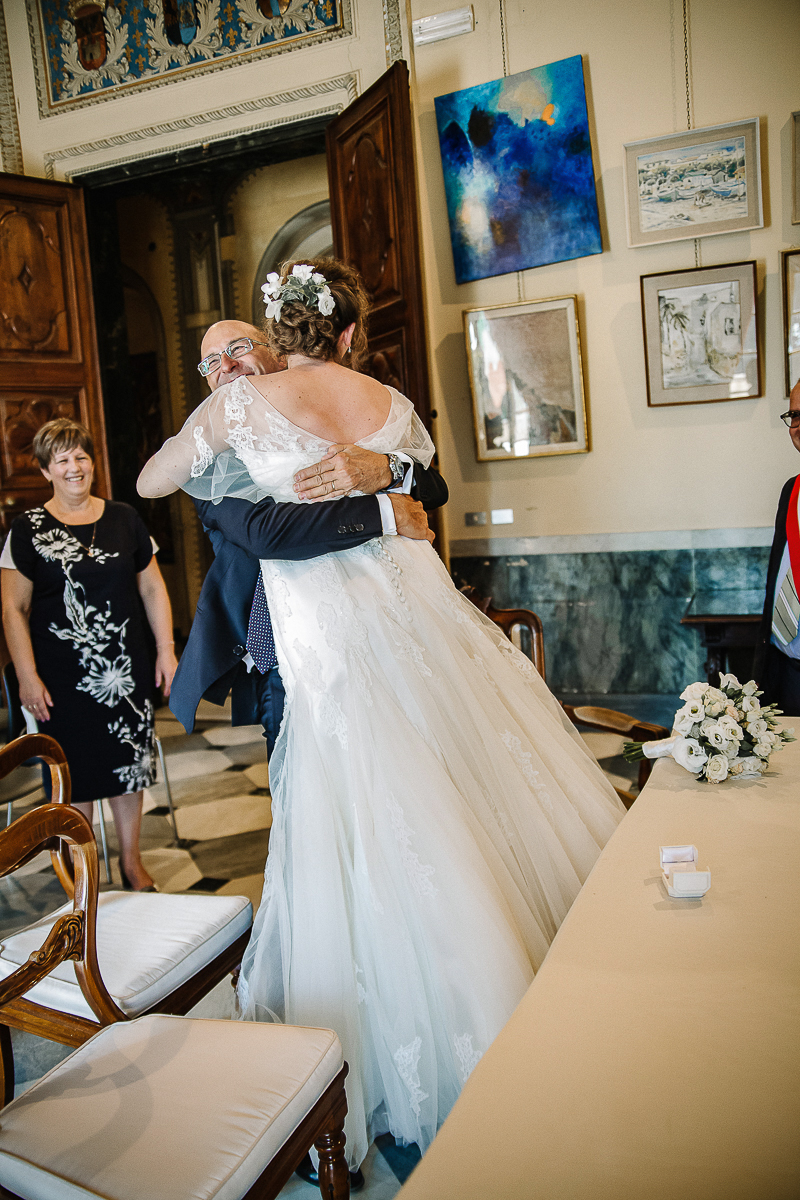 Destination wedding ad Arenzano (GE). Cerimonia civile presso il municipio di Arenzano. Abbraccio fra la sposa e il testimone