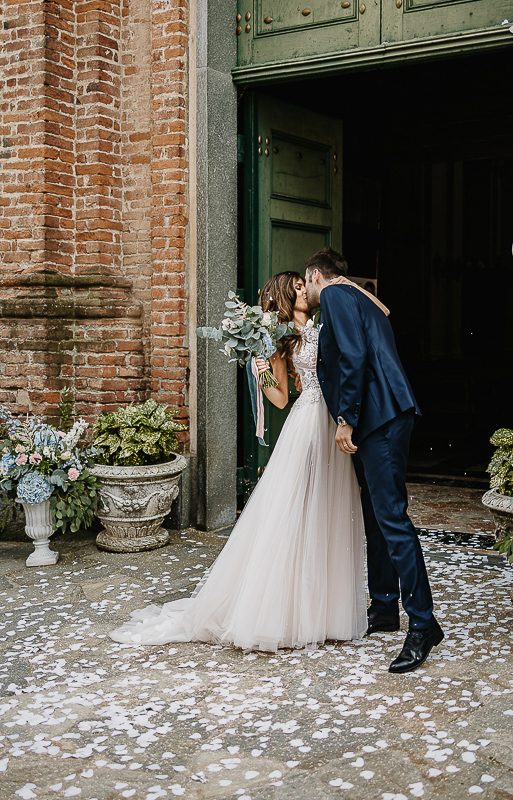 Matrimonio nella chiesa parrochiale di Arignano. Cerimonia.Lancio dei petali. Sposi che si baciano