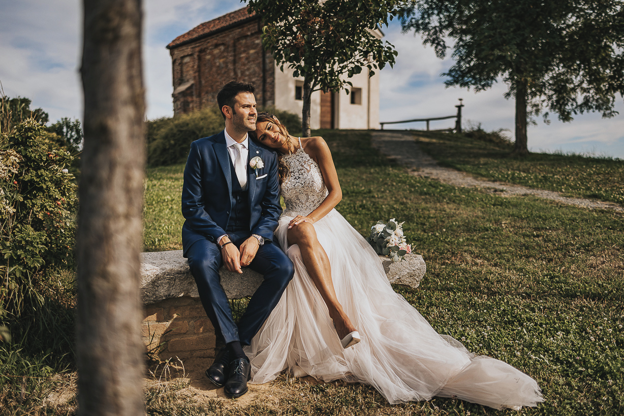 Chiesa di San Lorenzo a Mombello Torinese, sessione di coppia del matrimonio di Alice e Raffaele. Sposi seduti alla panchina