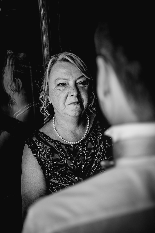 Matrimonio ad Arignano. Preparazione dello sposo.Mamma che guarda lo sposo.
