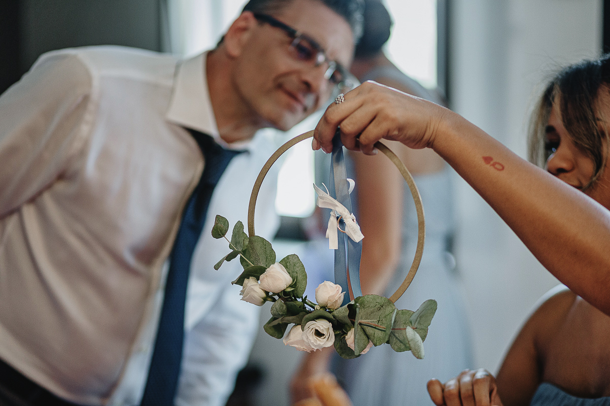 Matrimonio ad Arignano. Preparazione della sposa. Papà che guarda gli anelli sul portaanelli particolare.