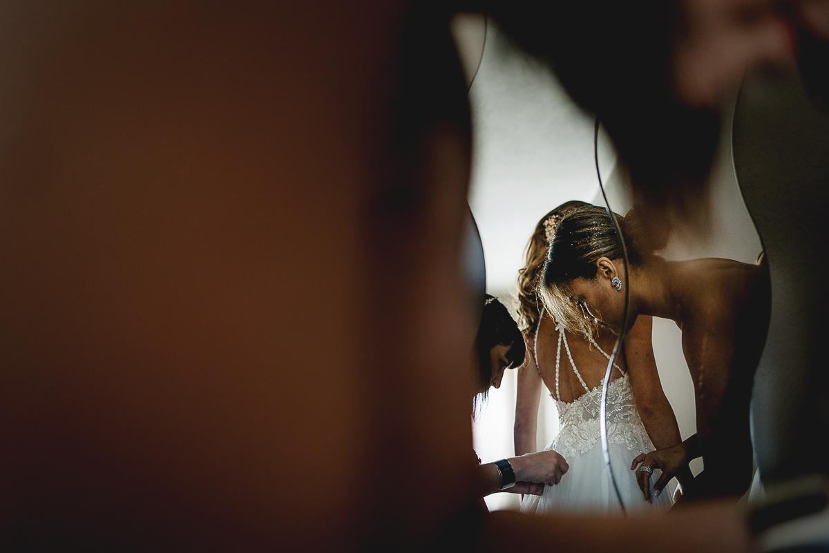Matrimonio ad Arignano. Preparazione della sposa. Vestizione della sposa. Particolare della schiena riflessa nello specchio.