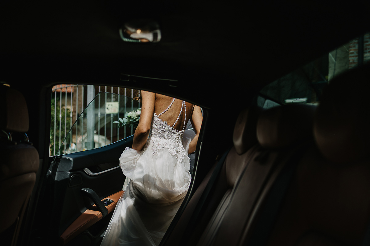 Matrimonio ad Arignano. Preparazione della sposa. Sposa che entra in auto.