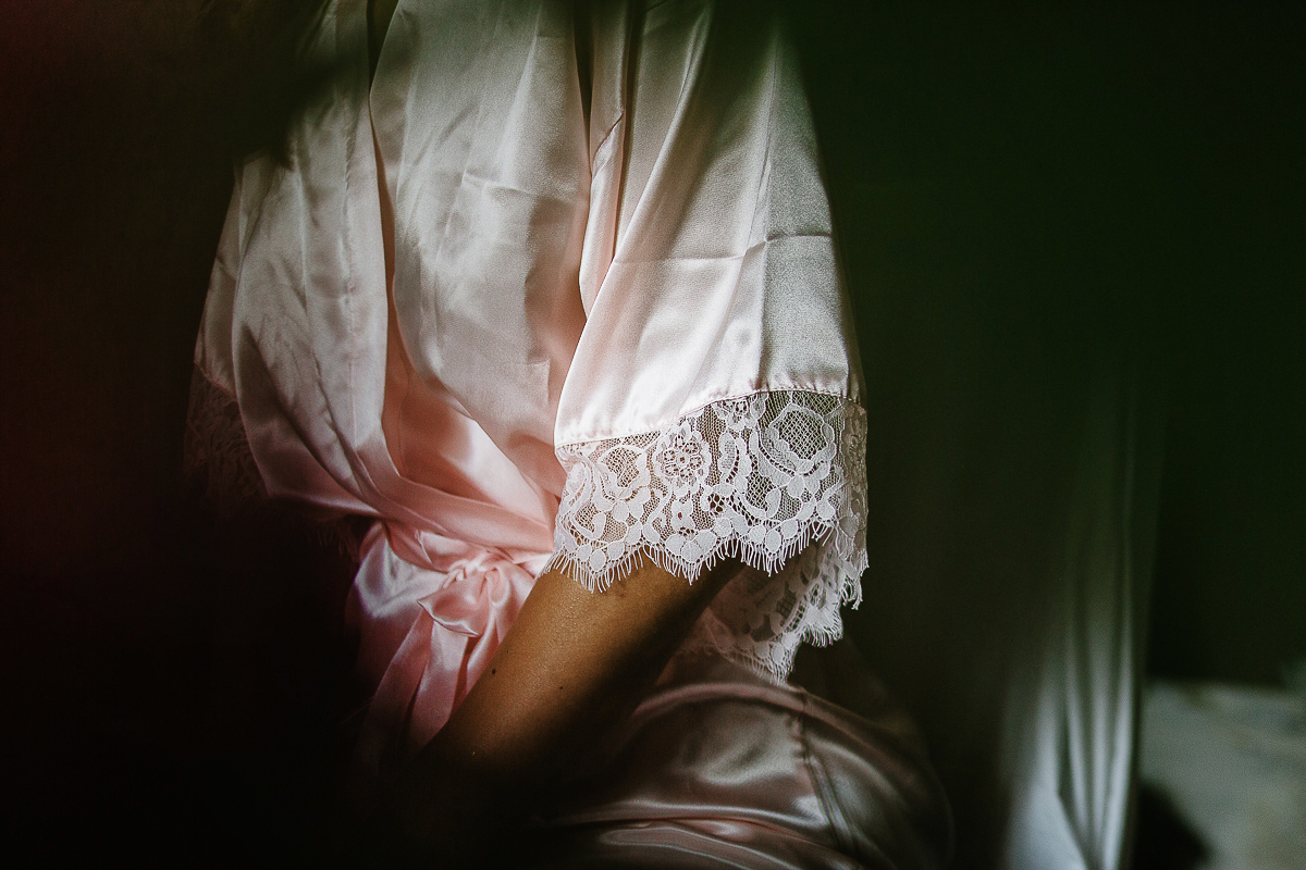 Matrimonio ad Arignano. Preparazione della sposa. Dettaglio del pizzo della vestaglia.