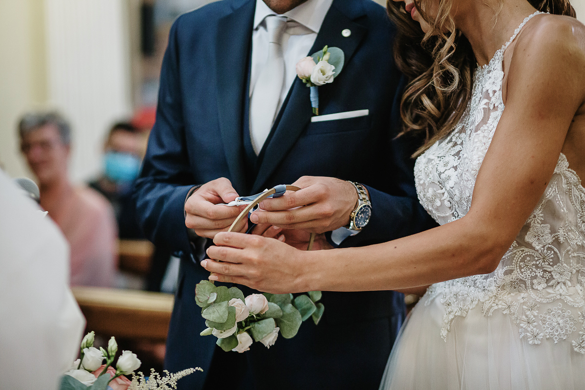 Matrimonio nella chiesa parrochiale di Arignano. Cerimonia.Sposo che sfila l'anello dal portaanello.