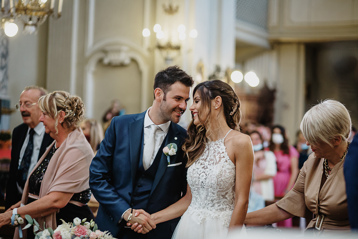Matrimonio nella chiesa parrochiale di Arignano. Cerimonia.Sposi che si guardano e si scambiano il segno della pace.