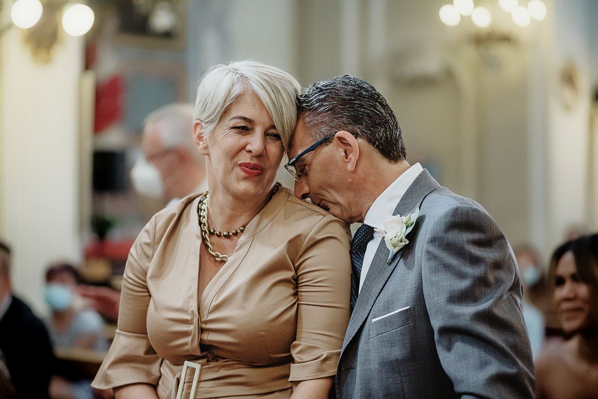 Matrimonio nella chiesa parrochiale di Arignano. Cerimonia.Padre della sposa che bacia la moglie sulla spalla.