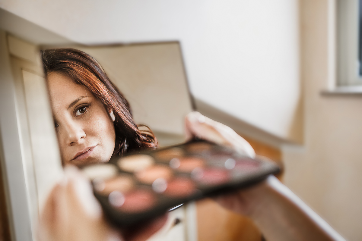 Castello dei Solaro, matrimonio di Noemi e Pietro. Preparazione della sposa.make-up. sposa riflessa nello specchietto della palette degli ombretti.