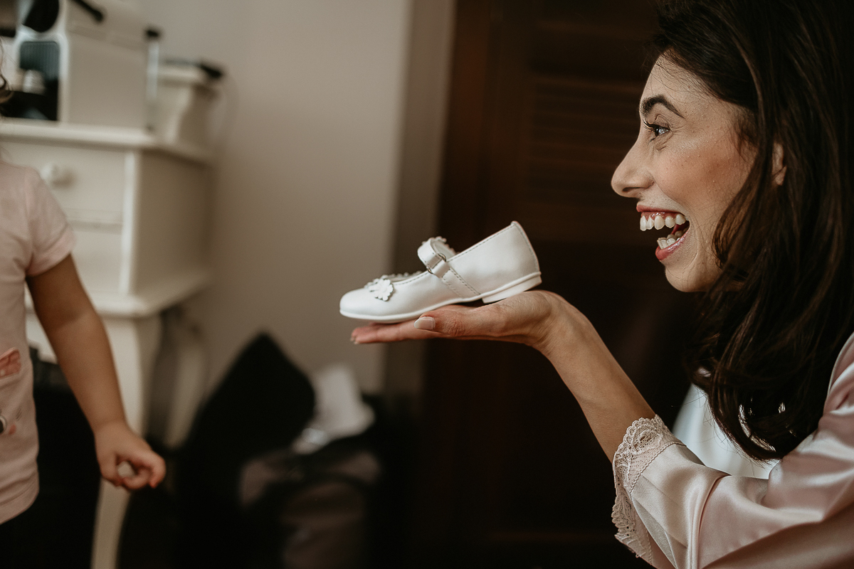 Tenuta La Cascinetta di Buriasco. Matrimonio. Preparazione della sposa. Sposa che mostra la scarpina alla sua bambina.